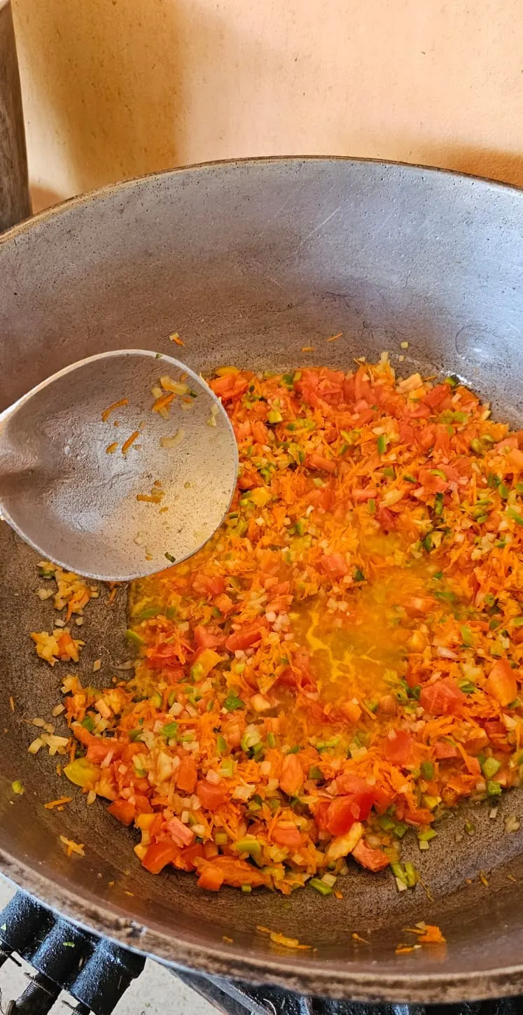 Vegetables cooking in a large pot for a feeding program